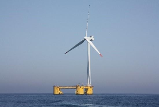 a floating wind turbine in the distance surrounded by water