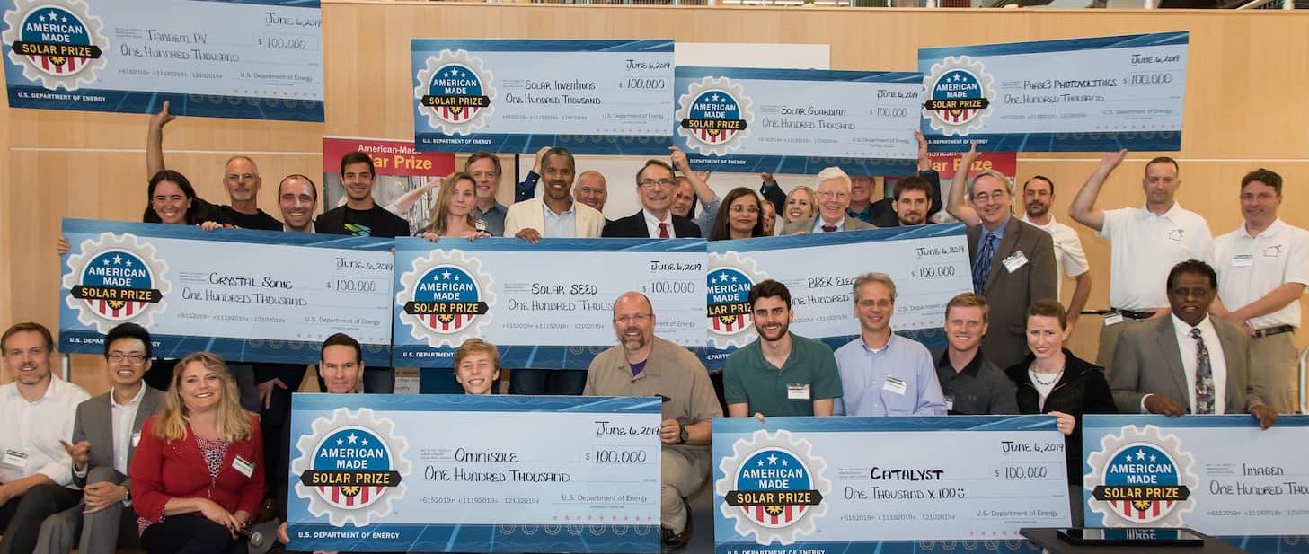 Group photo of American-Made prize winners holding large checks.